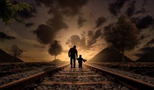 pai e filho numa linha de trem caminhando