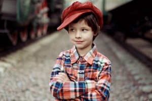menino com camisa xadrez e boina vermelha